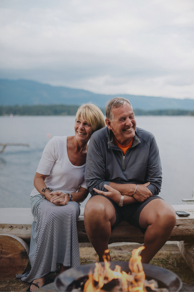 Mature couple at lakeside firepit