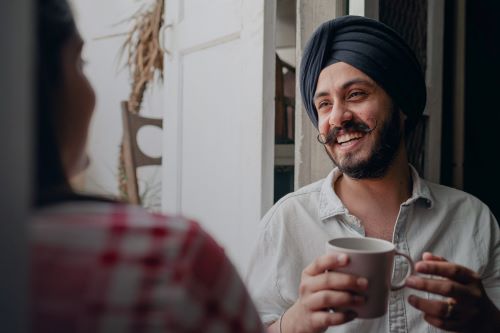 Man laughing while holding a mug