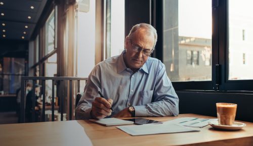 Man doing paperwork in a cafe